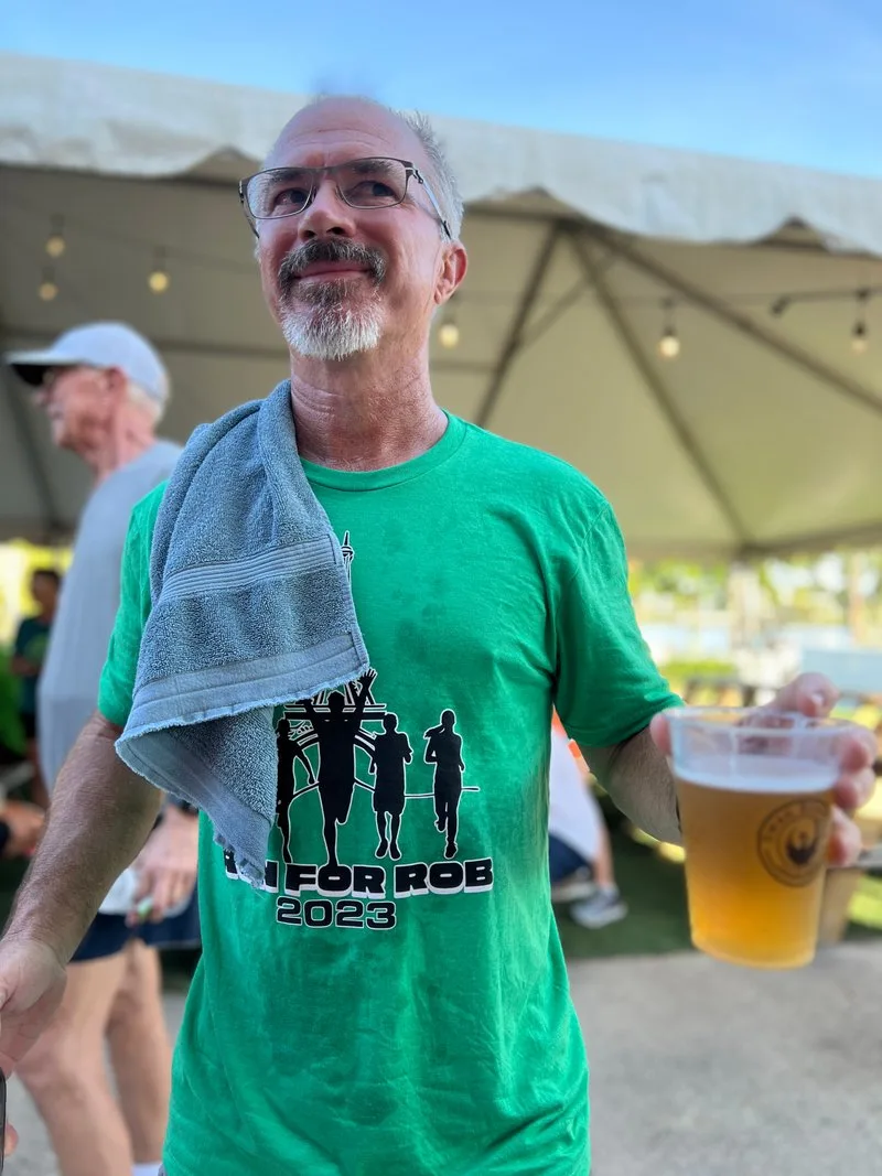 Guest enjoying a beer on the covered lakefront patio at Swan Brewing